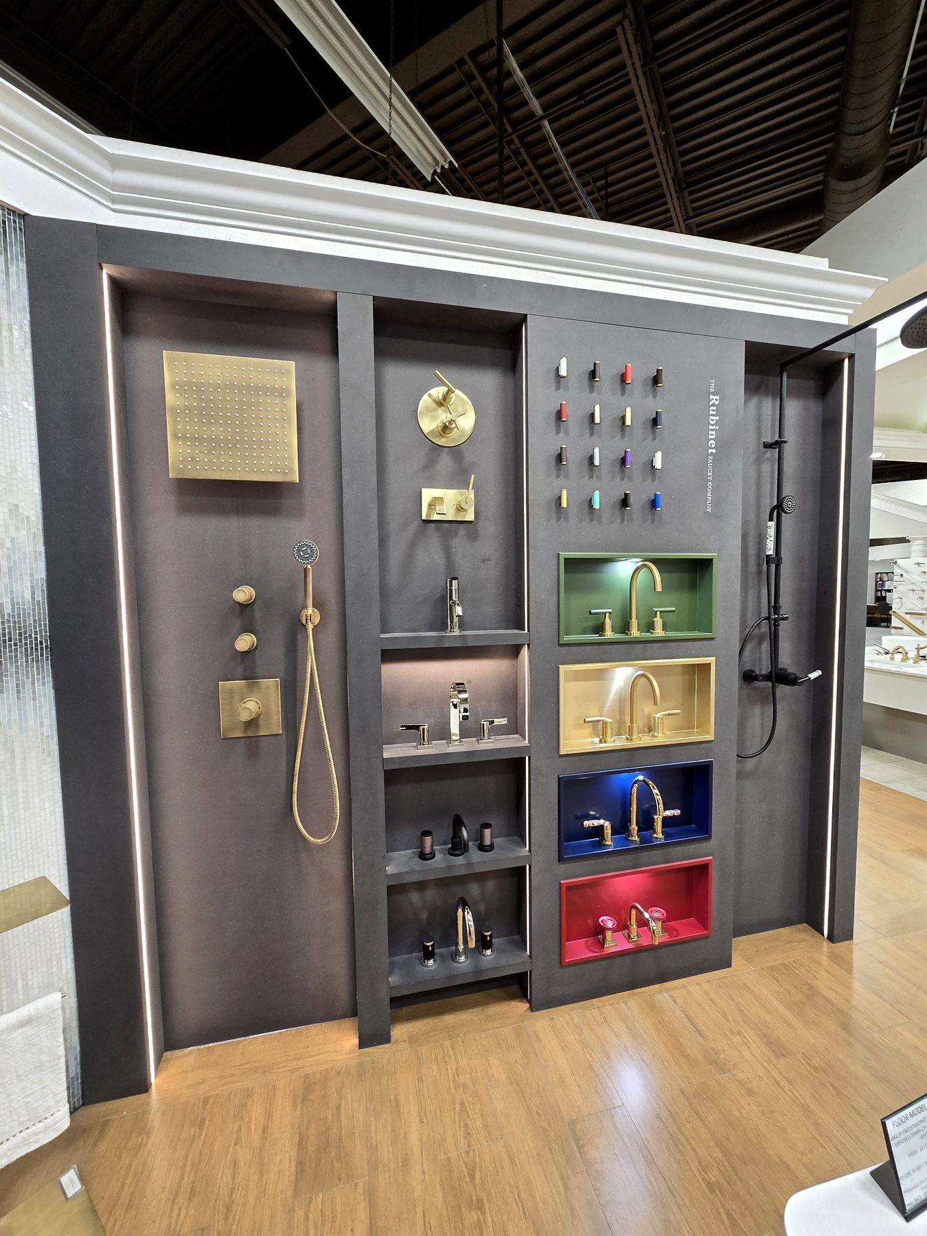 Brand display wall with coloured niches and brass fixtures